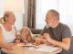 Grandparents and a child bond over painting at a cozy home setting, smiling and focused.