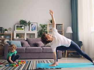 a woman and a child doing yoga in a living room